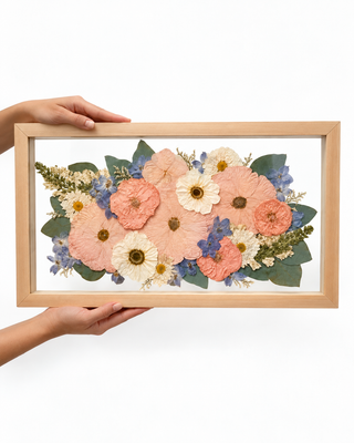 Pressed wedding bouquet featuring peach, blush, cream, and blue flowers arranged in a birch 20x10 floating frame by Forgiven Flower.