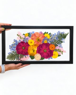 Colorful pressed wedding bouquet featuring magenta, coral, yellow, pink, and blue flowers in a black 20x10 double-glass floating frame by Forgiven Flower.