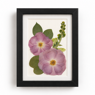Custom pressed wedding flowers featuring two pink-lavender blooms with green foliage in a classic black frame with a white mat by Forgiven Flower.