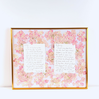 Close-up of individually pressed pink and white wedding flowers arranged in custom floral artwork.