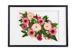 Custom pressed wedding flowers in shades of blush pink, rose, and magenta with lush green foliage, arranged in a classic black frame with a white mat by Forgiven Flower.