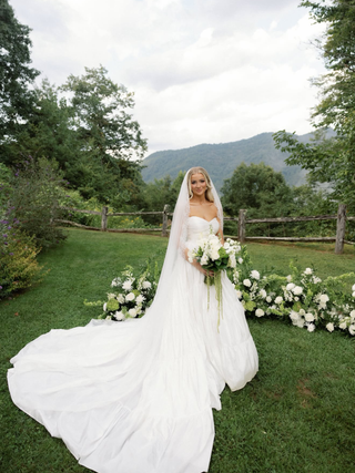 One of the Forgiven Flower brides holding her wedding bouquet on her wedding day before having it preserved by Forgiven Flower into a work of framed art.