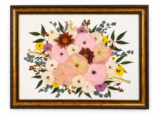 A colorful pressed wedding bouquet in a vintage, antique, gold frame