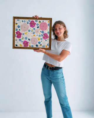 Custom pressed flower artwork featuring colorful preserved blooms in a decorative vintage-style frame by Forgiven Flower.