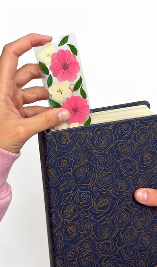 Pressed floral bookmark being used in a Bible.